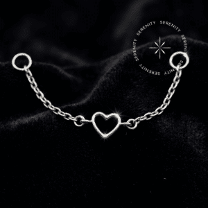 Uma geometria romântica esculpida com precisão estrutural para conexões de alto luxo limpo. ✦ ─────────── ✧ SERENITY ✧ ─────────── ✦ TN1820 - Corrente Coração Central - Titânio Grau Implante (ASTM F136) ✦ ─────────── ✧ SERENITY ✧ ─────────── ✦ 🛠️ ESPECIFICAÇÕES TÉCNICAS: Material Base: Titânio Grau Implante (ASTM F136) Mecanismo: Argolas de conexão nas extremidades (Compatível com hastes e argolas de até 1.6mm de espessura) Dimensões: Comprimento total de 36mm; espessura da malha de 0.6mm Gemas: Sem pedrarias (Metal solidamente esculpido) Cor: Prateado natural do metal Venda: 1 Unidade (Hastes e topos de conexão vendidos separadamente) ✦ ─────────── ✧ SERENITY ✧ ─────────── ✦ O Piercing Corrente Coração em Titânio foi projetado para elevar a estética do seu setup, transformando perfurações isoladas em uma composição de alto luxo limpo. Afastando-se de qualquer obviedade, esta peça traz uma malha fluida de 0.6mm interceptada por uma silhueta de coração perfeitamente vazada e polida. O contraste sofisticado contra a pele oferece uma presença marcante, fundindo a leveza arquitetônica com a força inabalável do titânio puro. Por que o Piercing Corrente Coração em Titânio é sinônimo de alta qualidade? Desenvolvida para máxima durabilidade e conforto contínuo, a malha desta corrente não retém resíduos e acompanha o movimento natural do corpo sem causar tensões nas perfurações. O coração central é esculpido em bloco único com bordas impecavelmente polidas, garantindo um brilho contínuo do metal e uma integridade estrutural perfeita. É o encontro definitivo entre a vanguarda do design corporal e o rigor da engenharia de materiais de elite. Uma peça de tiragem restrita, esculpida com precisão cirúrgica. Eleve seu setup enquanto a curadoria atual está disponível. ✦ ─────────── ✧ SERENITY ✧ ─────────── ✦ Por que optar pelo Piercing Corrente Coração em Titânio para o seu setup? Sua estrutura maleável abraça a anatomia com um caimento escultural, criando uma conexão luminosa e fluida que exala uma elegância irrestrita e absolutamente segura para o uso diário. ✦ ─────────── ✧ SERENITY ✧ ─────────── ✦ 📍 CURADORIA ANATÔMICA: (Nota de Estilo: Esta é uma joia de conexão. As argolas nas extremidades devem ser inseridas nas hastes ou argolas base já existentes) Escafa/Flat e Hélix: Cria uma ponte estrutural sofisticada e envolvente, interligando dois furos na curvatura superior da orelha com um caimento que estabelece o coração como ponto focal absoluto. Concha/Conch (Conexão ao Lóbulo ou Hélix): Transforma o Conch no centro de uma composição majestosa. A corrente envolve a lateral da orelha com fluidez, adicionando uma camada de alta joalheria que se adapta aos contornos auriculares perfeitamente. Lóbulo: Ideal para conectar perfurações duplas ou triplas, desenhando um caminho cintilante e dinâmico que exala autoridade estética e romance arquitetônico. Nariz (Nostril Chain): Uma aplicação de vanguarda e altíssimo luxo. Conectando duas perfurações nas abas nasais, a corrente repousa sobre a ponte do nariz com uma simetria impecável, onde o coração atua como um adorno de design formidável. ✦ ─────────── ✧ SERENITY ✧ ─────────── ✦ ⭐ DESTAQUES EXCLUSIVOS: Material de Elite: Forjada integralmente em Titânio Grau Implante (ASTM F136), entregando leveza absoluta e biocompatibilidade irrestrita. Engenharia de Encaixe: Malha de 0.6mm desenhada para não enroscar, com argolas terminais compatíveis de forma universal com hastes e joias de 1.0mm, 1.2mm e até 1.6mm de espessura. Design Escultural: Silhueta de coração vazada meticulosamente integrada ao centro da malha, garantindo simetria exata e equilíbrio de peso perfeito. Polimento Espelhado: Acabamento premium impecável que realça a nobreza da coloração prateada natural, garantindo uma superfície lisa, brilhante e livre de porosidade. ✦ ─────────── ✧ SERENITY ✧ ─────────── ✦ PUREZA ABSOLUTA E PERSONALIZAÇÃO - TITÂNIO GRAU IMPLANTE: Desfrute da coloração prateada natural do titânio em sua forma mais nobre, ou personalize sua joia! Oferecemos a opção de alterar a cor da sua peça através do processo de anodização. Essa tecnologia utiliza alta voltagem para reestruturar a superfície do metal, refletindo tons vibrantes de forma segura, sem o uso de tintas ou banhos químicos, mantendo 100% da pureza e da biocompatibilidade. ✦ ─────────── ✧ SERENITY ✧ ─────────── ✦ 💎 COMPROMISSO DE EXCELÊNCIA (CUIDADOS E GARANTIA): Selo de Garantia: 1 ano contra defeitos estruturais e de fabricação. Manutenção: Utilize apenas sabão neutro, água morna e secagem imediata. 🚨 ATENÇÃO: A troca por arrependimento só será aceita caso o lacre inviolável esteja intacto, garantindo a higiene.