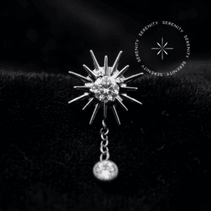 piercing titânio grau implante modelo topo sol cravejado com pingente de zircônias translúcidas, repousando suavemente sobre um tecido de cetim branco de alta opulência.
