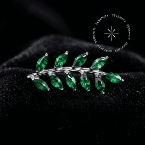 Piercing rosca interna titânio com design escultural de galho e dez pétalas finamente cravejadas, repousando suavemente sobre um tecido de cetim branco de alta opulência.