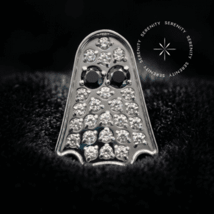 piercing titânio grau implante com design lúdico de fantasma cravejado de zircônias translúcidas repousando suavemente sobre um tecido de cetim branco de alta opulência.