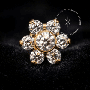 Piercing Topo Flor em Titânio com polimento espelhado impecável e zircônias de lapidação premium, capturando a luz em um ambiente de alto luxo, apresentando design simétrico de seis pétalas radiantes.