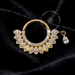 Argola Frontal Duplo Cravejado utilizada como piercing, forjada em Titânio Revestido de Ouro 18k com duas fileiras de zircônias premium e um pingente de gota pendente, fotografada em fundo claro.
