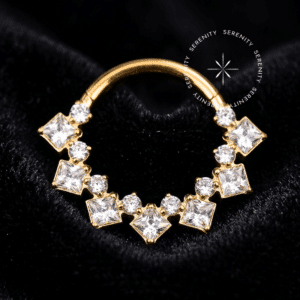 Argola Frontal 15 Zircônias em titânio revestido de ouro 18k sobre fundo branco, joalheria de corpo Serenity.