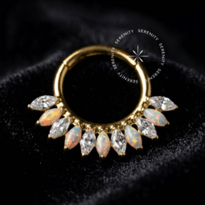 Argola Frontal Navetes Opala utilizada como piercing, forjada em Titânio Revestido de Ouro 18k com coroa alternada entre zircônias cristais e opalas sintéticas em formato alongado, fotografada em fundo claro.