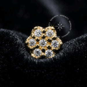 Topo Flor 7 Pétalas Ouro 18K cravejado com zircônias premium em fundo branco, joalheria de corpo Serenity.