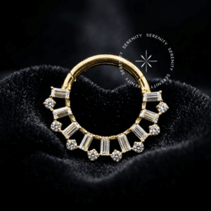 Argola Frontal Coroa Baguetes utilizada como piercing, forjada em Titânio Revestido de Ouro 18k com coroa cravejada de zircônias premium transparentes em formato retangular, fotografada em fundo claro.