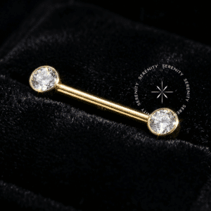 Par de Piercing de Mamilo Cristal em Titânio Revestido de Ouro 18k, destacado em fundo preto profundo (Noir) para máxima fidelidade de brilho.