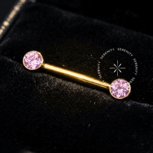 Par de Piercing de Mamilo Rosa em Titânio Revestido de Ouro 18k, destacado em fundo preto profundo (Noir) para máxima fidelidade de brilho.