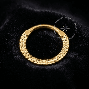 Argola frontal martelada titânio revestido de ouro 18k com textura orgânica para perfurações de septo e daith.