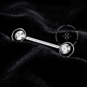 Par de Piercing de Mamilo TN875 com design de Saturno em Titânio Grau Implante polido e zircônia, sobre fundo preto Noir.