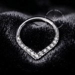 Argola Septo Titânio com design em gota cravejada frontalmente em zircônias premium translúcidas, encaixe articulado tipo clicker, ideal para perfurações de septo e daith.