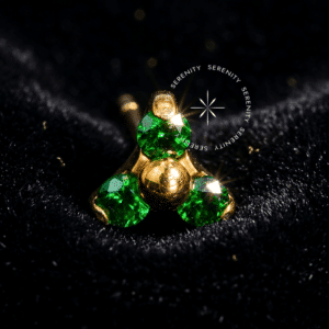 (Alt Text): Piercing Titânio Push Pin Trinity com 3 zircônias verde esmeralda em titânio revestido de ouro 18k, design triangular de luxo, ideal para lóbulo, hélix e flat com segurança e brilho.
