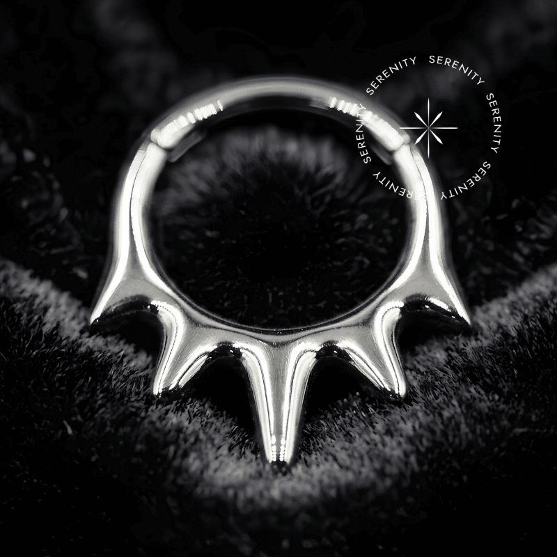 argola septo titânio com design frontal em coroa de cinco pontas oficiais e cónicas, equipada com fecho clicker em titânio de grau implante polido com acabamento espelhado para perfurações de septo ou daith.