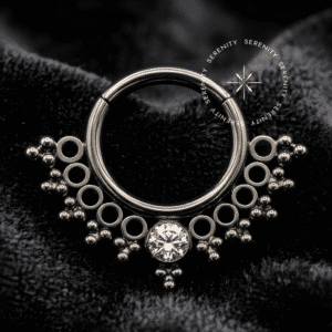 argola septo titânio com design rendado em estilo indiano e gema central em formato de gota de zircônia cúbica brilhante, fecho articulado clicker em titânio de grau implante.