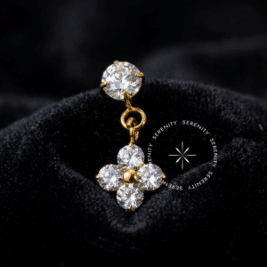 Piercing Titânio Dourado com pingente formato trevo cinético, base lisa dourada com zircônia redonda e parte inferior articulada composta por quatro zircônias formato coração ou gota, pino liso estilo push pin por pressão, focado em alta joalheria para lóbulos e hélix.