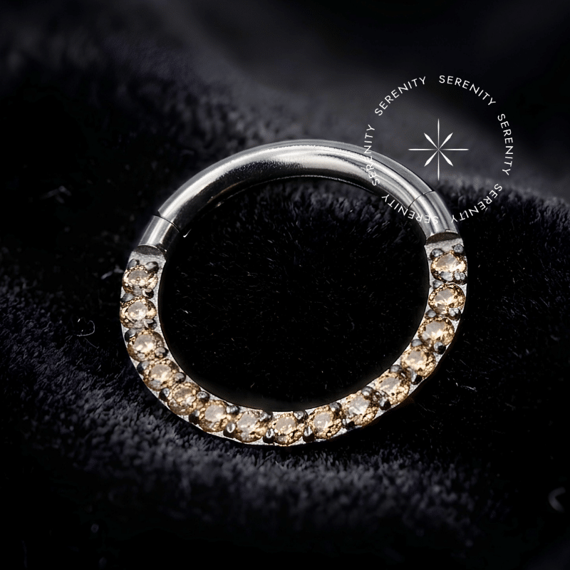 Argola Septo Titânio com cravação frontal de Zircônias Premium Champanhe Imperial, fecho articulado clicker de alta segurança anatômica, ideal para perfurações de alto impacto visual como septo e daith.