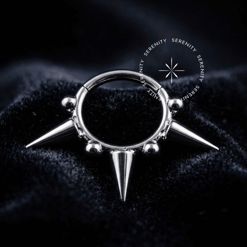 argola click titânio de segmento com spikes proeminentes e esferas integradas na borda externa, superfície super polida, abertura em clicker usinada invisível, com finalidade anatômica impecável para uso como piercing de septo e daith.