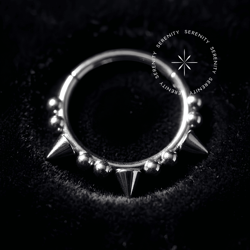 argola click titânio com design frontal adornado por esferas simétricas e três spikes proeminentes de pontas perfeitas, fecho de encaixe articulado invisível, finalidade estrita para uso luxuoso no septo e daith.