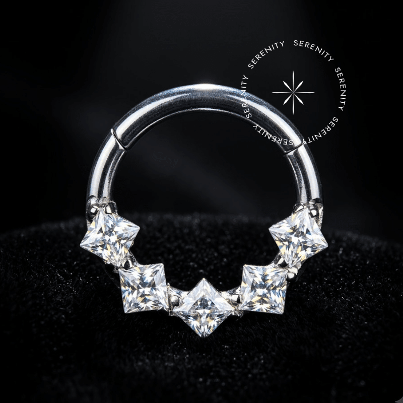 Argola Septo Titânio em tonalidade prateada natural com pedras Zircônia Premium de lapidação quadrada encravadas na face frontal externa, fecho clicker articulado, ideal para perfurações centrais como septo e daith.