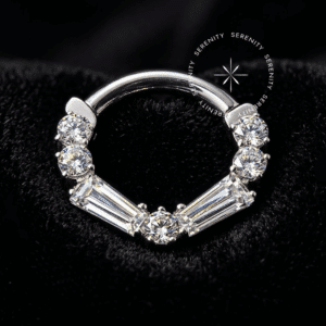 Argola Clicker em Titânio Grau Implante de cor prata metálica, exibindo cravagem frontal de zircónias em lapidação geométrica baguete, com fecho de dobradiça invisível, projetada especificamente para perfurações de septo e daith.Título: argola-clicker-titanio-baguete-frontal-tn697