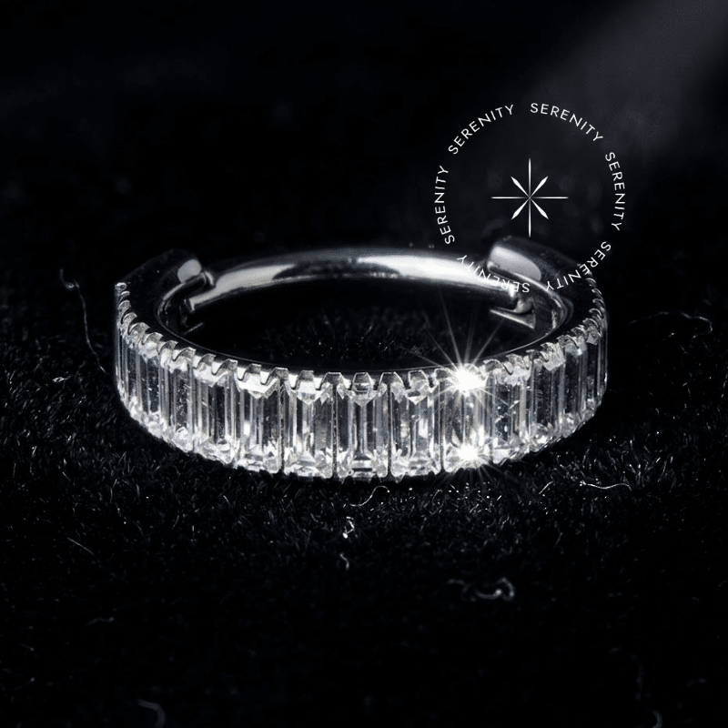 Argola clicker titânio em acabamento prateado com cravação frontal contínua de pedras em lapidação baguette, confeccionada em Titânio Grau Implante para perfurações de septo e daith.
