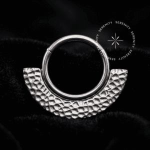 argola septo titânio com design de leque textura martelada orgânica, fecho clicker integrado, projetada com cravação frontal exclusiva para perfurações de septo e daith.