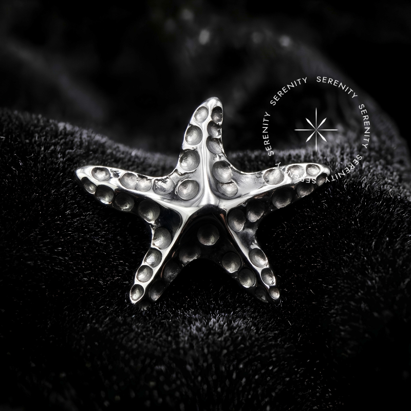 Piercing Titânio Push Pin com design em formato texturizado de estrela do mar e encaixe por pressão de alta segurança, confeccionado em Titânio Grau Implante (ASTM F136) polido, ideal para finalização de curadorias luxuosas, conforme visto na image_07c37e.png.