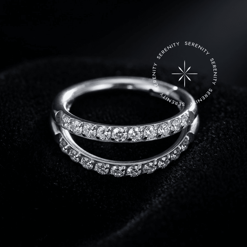 Argola Click Titânio com design de linha dupla e textura cravejada, abertura clicker articulada, ideal para brilho intenso em perfurações de cartilagem lateral.