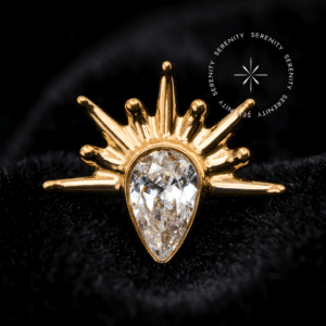 Piercing titânio dourado com design de gota irradiante e raios esculturais, fecho em rosca interna compatível com labret, ideal para curadoria luxuosa em cartilagens como helix e flat.