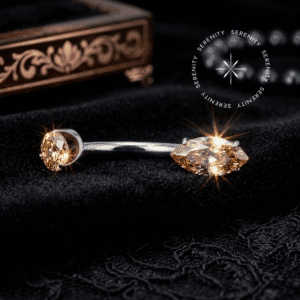 Piercing Umbigo Titânio anatômico apresentando haste curva polida de 1.6mm x 10mm, finalizado por um topo esférico de 4.0mm e uma suntuosa base em Zircônia Premium Oval de 4.0mm x 7.0mm na cor Champagne Imperial. A peça de alta joalheria possui sistema cirúrgico de rosca interna de 1.2mm e foi fotografada em lente macro sobre as texturas luxuosas de um impecável e brilhante tecido de cetim branco puro.