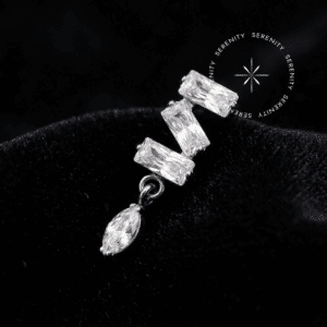 Piercing Titânio Grau Implante com design cravado apresentando três zircônias premium em lapidação baguette e uma navete pendente translúcido majestic, encaixe em pino de rosca interna atraumática, repousando de forma a refletir a luz como um tecido de cetim liso, brilhante e branco puro, ideal para flat e conch em setups de alta joalheria piercing.