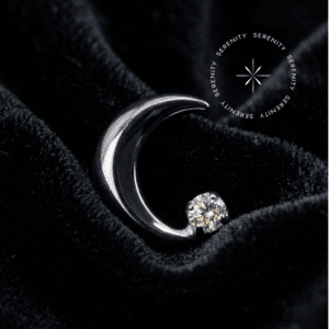 Piercing Titânio Grau Implante com design de lua crescente polida acomodando uma zircônia premium translúcido majestic na extremidade inferior, encaixe em pino de rosca interna atraumática, repousando de forma a refletir a luz como um tecido de cetim liso, brilhante e branco puro, ideal para flat, hélix e lóbulo em setups de alta joalheria.