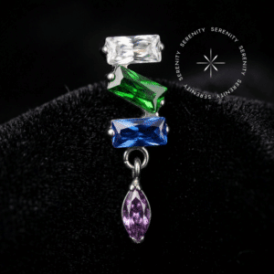 Piercing Titânio Grau Implante com design cravado apresentando três zircônias premium em lapidação baguette nas cores translúcido, verde e azul, e uma navete pendente rosa blush, encaixe em pino de rosca interna atraumática, repousando de forma a refletir a luz como um tecido de cetim liso, brilhante e branco puro, ideal para flat e conch em setups de alta joalheria piercing.