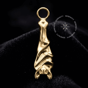 Pingente Morcego Titânio com polimento espelhado dourado, argola superior lisa para adaptação fluida e movimento em setups alternativos de luxo no septo e lóbulo.