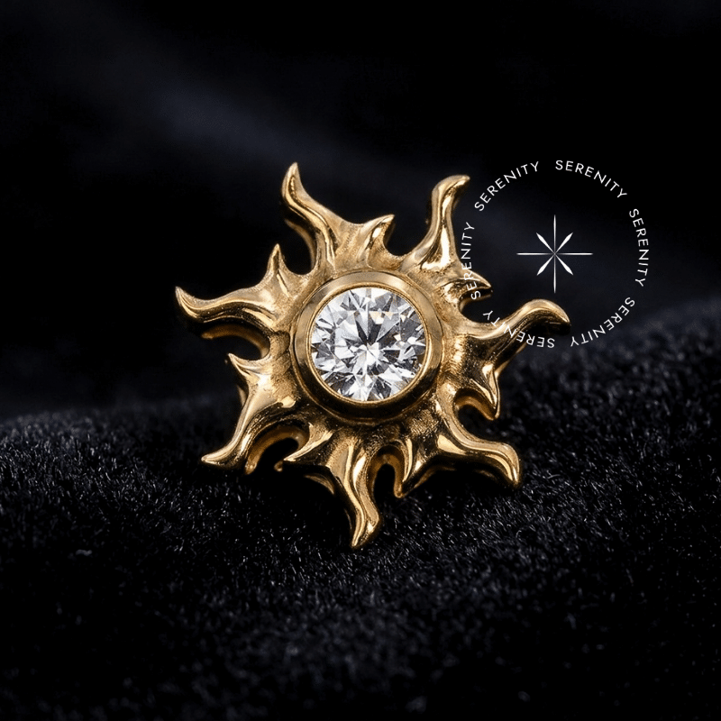 Piercing Titânio Dourado em formato de Sol Místico estilizado com raios perfeitamente delineados, abrigando uma Zircônia Premium Translúcida de lapidação redonda no centro. Superfície do metal hiperpolida exibindo pino de rosca interna de 0.9mm. Fotografia macro de luxo focada nos reflexos de luz, ideal para curadorias de alto padrão no hélix, conch e lóbulo.