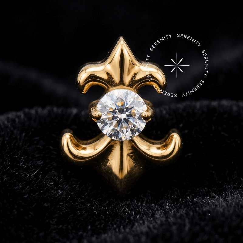 Piercing Titânio Dourado em formato escultural de Flor de Lis abrigando uma Zircônia Premium Translúcida cravada no centro. Superfície do metal hiperpolida exibindo pino de rosca interna de 0.9mm de espessura. Fotografia macro de altíssima definição focada nos reflexos dramáticos de luz, ideal para curadorias requintadas de cartilagem, conch e lóbulo.