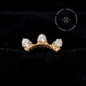 Piercing cartilagem ouro 18k em formato de arco, coroado com três Zircônias Premium Translúcidas, mecanismo de fixação por rosca interna, repousando de forma imponente, da exclusiva marca Serenity.