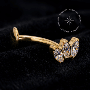 Piercing umbigo ouro 18k modelo floating de 1.6mm com haste de titânio biocompatível e topo push pin cravejado com três Zircônias Premium navetes na cor Amarelo Imperial, repousando de forma esplêndida da exclusiva marca Serenity.