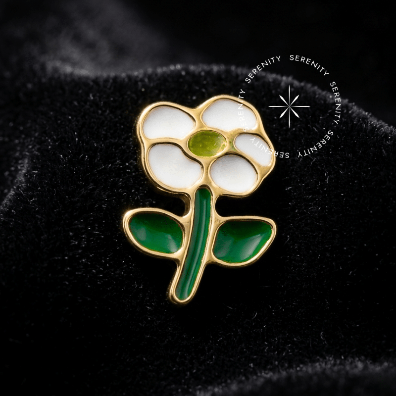 Piercing titânio dourado topo flor resinada nas cores branca e verde, com acabamento metálico brilhante e encaixe de rosca interna de 0.9mm, ideal para composições anatômicas de luxo.