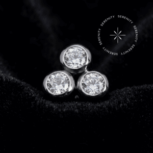 Piercing Titânio Push Pin com design Trinity e três pedras de Zircônia Premium radiantes, encaixe threadless seguro, ideal para tragus e microdermal, destacando-se como uma joia de luxo corporal em superfície.