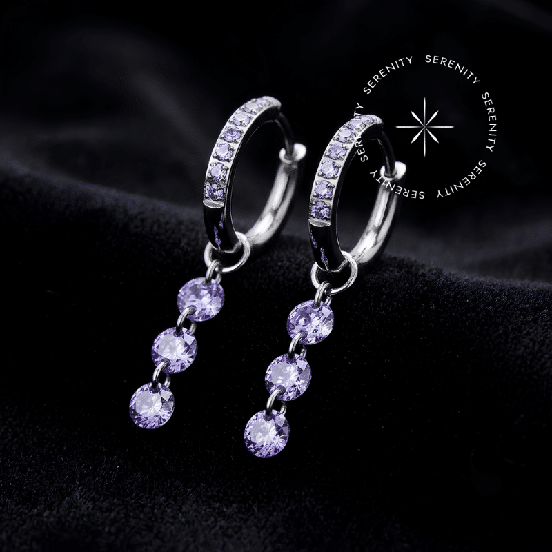 argola click titânio com pingente alongado em cascata cravejado com três Zircônias Premium Roxo Imperial, fecho articulado, ideal para curadoria luxuosa no lóbulo.