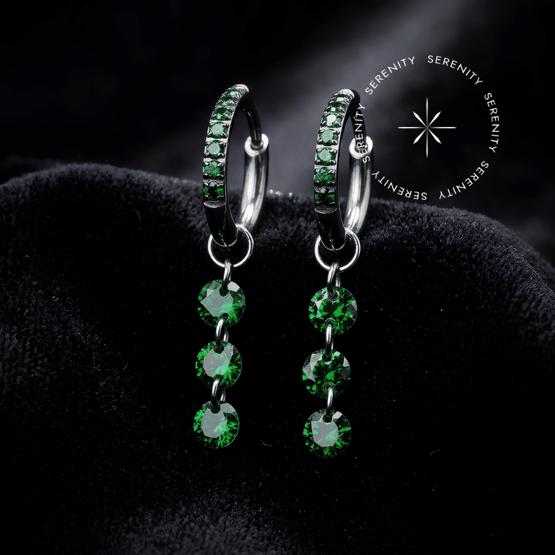 Argola Click Titânio com pingente alongado em cascata cravejado com três Zircônias Premium Verde Esmeraldina, fecho articulado, ideal para curadoria luxuosa no lóbulo.
