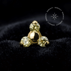 Fotografia macro do Topo Trinity Cravejado em Titânio Revestido de Ouro 18k com zircônias amarelas de lapidação premium brilhando intensamente.