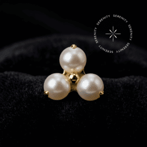 Topo Trinity Lux Pérola Push Pin em titânio revestido de ouro 18k com três pérolas sintéticas dispostas em formato triangular.