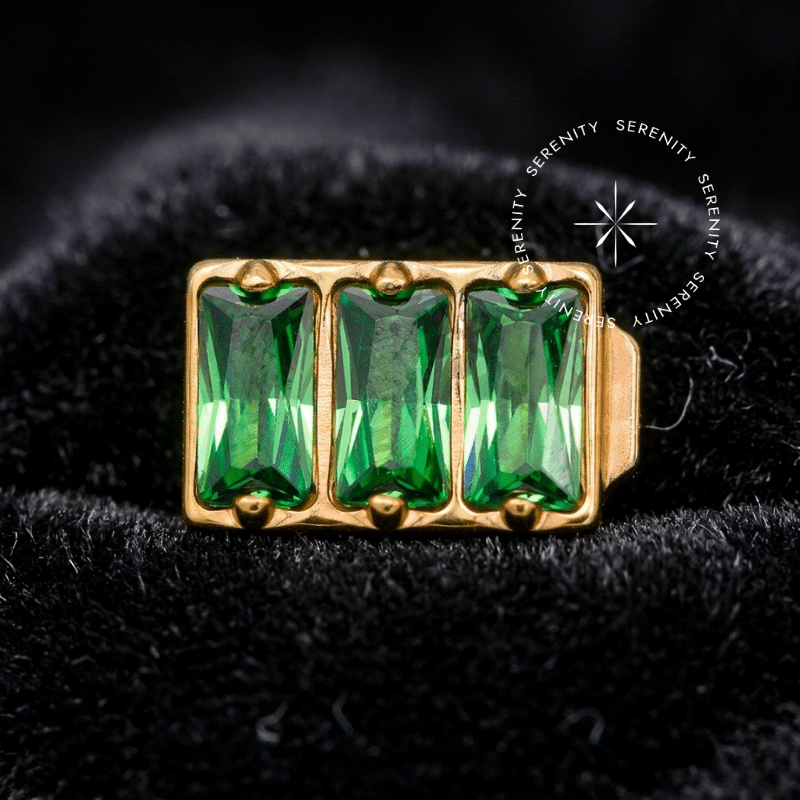 Piercing Titânio Dourado com top em formato retangular cravado com quatro Zircônias Premium Verde Esmeraldina, pino inferior de rosca compatível com hastes labret, design geométrico alongado perfeito para uso em hélix e conch, sobre fundo claro.