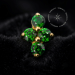 Topo Cravejado Mini Clover Verde em titânio revestido de ouro 18k com quatro zircônias verdes lapidadas em formato de trevo.