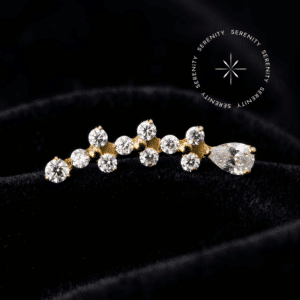 piercing titânio dourado em formato de topo cluster alongado evidenciando a união de três blocos trinitys finalizados por uma linda gota, cravados com Zircônia Premium Translúcido Majestic, pino de rosca interna liso de 0.9mm, forjado em titânio revestido em ouro 18k PVD repousando elegantemente, ideal para perfurações luxuosas em conch e hélix.