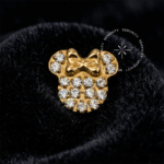 Piercing Titânio Dourado com topo esculpido no formato da silhueta da Minnie Mouse, enriquecido com um detalhe de laço, totalmente cravejado em pavê com Zircônias Premium Radiantes. Pino rosqueável inferior de 0.9 mm para fixação em labrets, exibido sobre fundo branco ressaltando a captação de luz e o luxo.