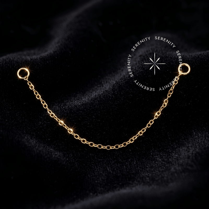 Corrente Piercing Titânio Dourado de elos ultrafinos com textura luxuosa, apresentando argolas terminais circulares nas pontas, ideal para conectar e emoldurar múltiplas perfurações na orelha.