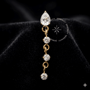 Piercing Rosca Interna Titânio dourado exibindo um topo em formato de gota com Zircônia Premium translúcida, de onde pende uma delicada corrente metálica de 18.7mm finamente cravejada com micro zircônias. Estrutura hipoalergênica com pino de rosca interna 0.9mm, repousando em fundo claro, projetada para perfurações de cartilagem e lóbulo.
